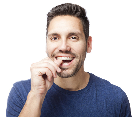 Man inserting a clear aligner into his mouth