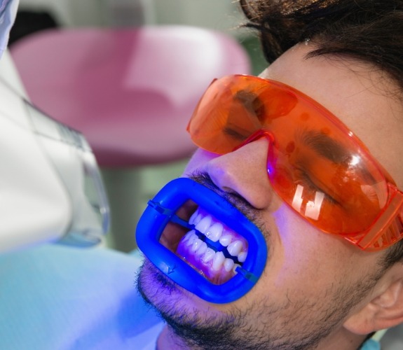 Man getting professional teeth whitening in dental chair