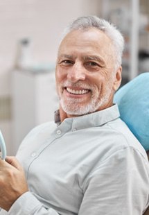patient smiling while sitting in dental chair 