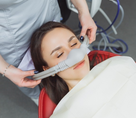 Dental patient wearing nitrous oxide mask over her nose