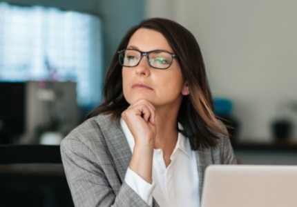 Woman resting her chin on her hand and looking contemplative