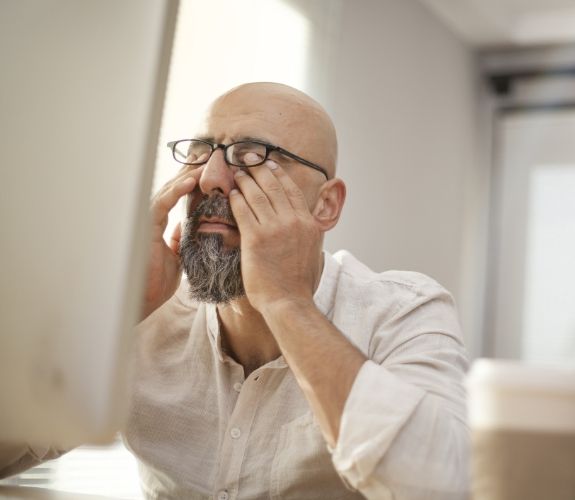 Tired man rubbing his eyes before sleep apnea treatment in South Elgin