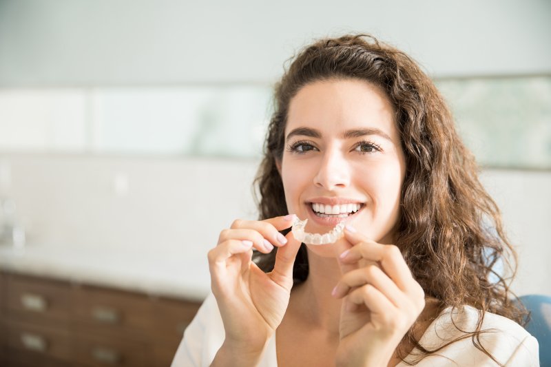 woman holding her clear aligner